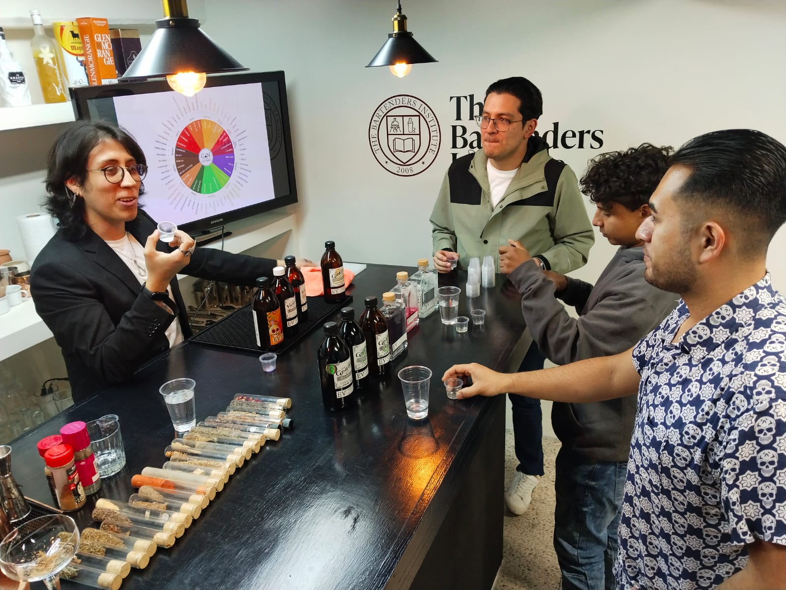 Alumnos en sesión real de barra en The Bartenders Institute Ciudad de México Roma Norte — análisis sensorial con destilados reales